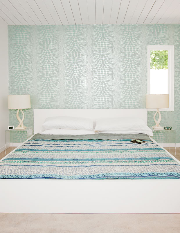 Bedroom with soft aquatic green walls and patterned duvet