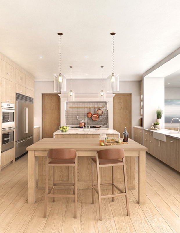 Large kitchen with wood island in centre with two barstools and light wood cabinetry