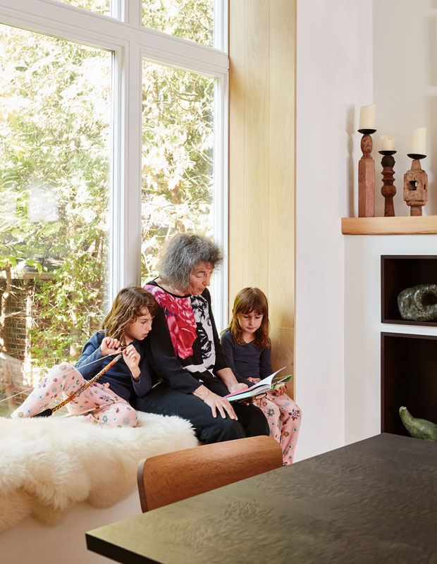 Modern Century Home dining room where a grandmother reads to the homeowners' daughters Rees and Tate on the window ledge.