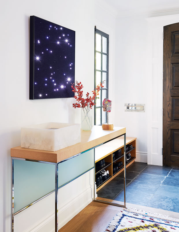 Entryway with a sleek side table and a wall hung painting of a purple starry sky.