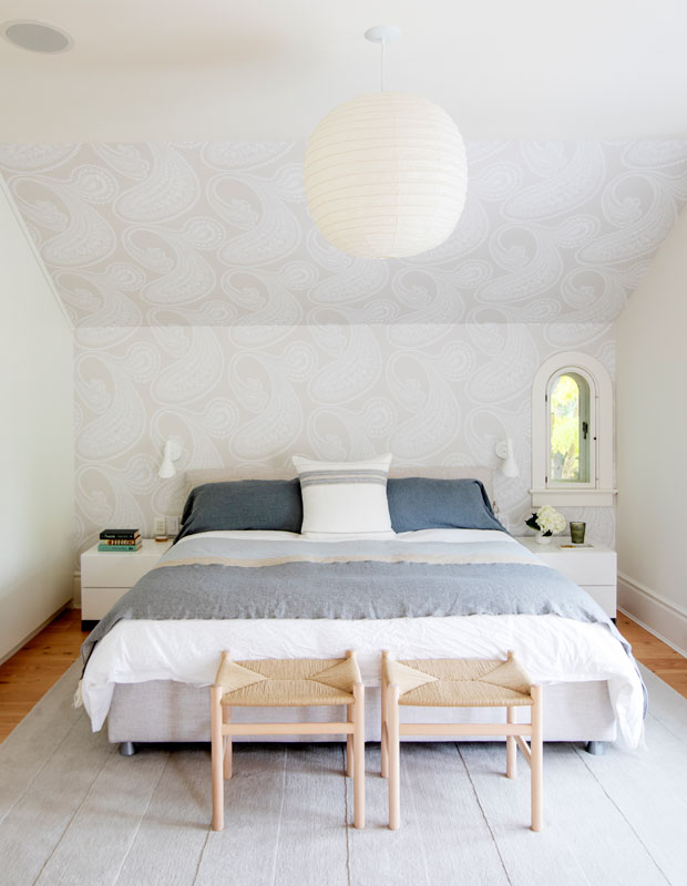 White and gray bedroom with beige swirl-patterned wallpaper on the back wall and ceiling