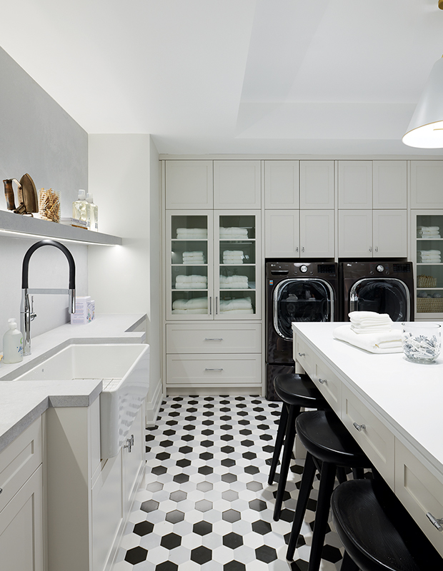 A graphic laundry room with black and white tiles doubles as a crafts room in the PMH showhome designed by Brian Gluckstein.