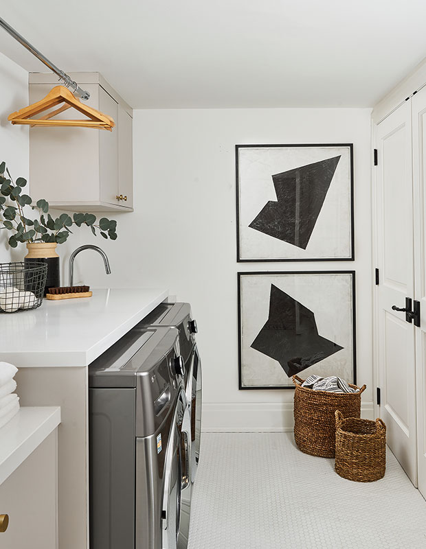 High-contrast art prints, woven baskets, penny tiles and fragrant eucalyptus elevate the style in this small laundry room.