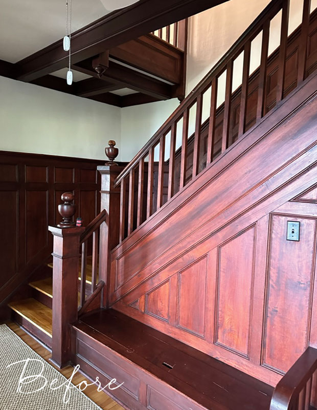 A before image of an dark wood staircase in a dark hallway lit only by natural light. old nova scotia home