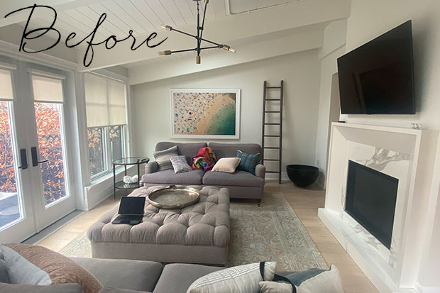 A large, high ceilinged living room with grey couches, grey walls, and a faded Persian rug. modern heritage townhouse