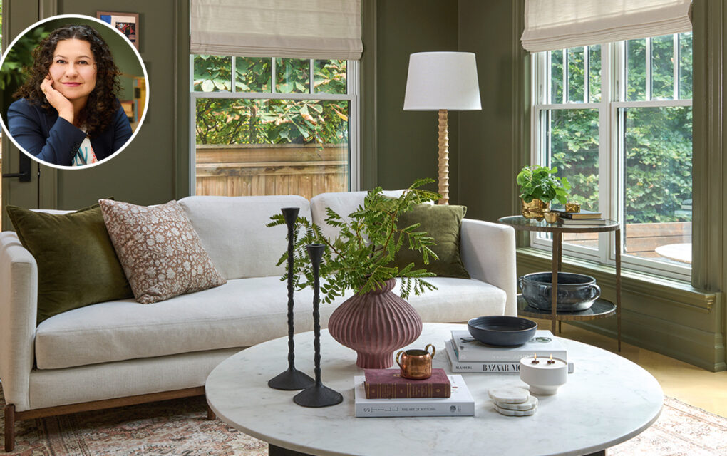 living room with deep-green walls, natural wood beams on high ceilings, and furnished with modern rounded furniture, in cool shades of white.