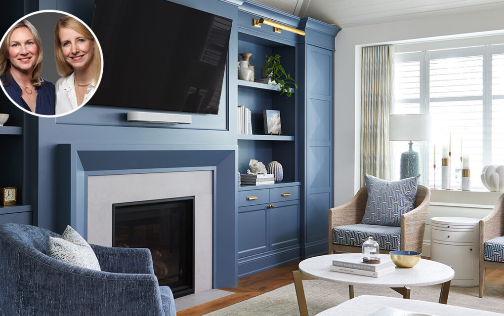 A clean, classic, modern living room with blue and grey decor, gold accents and hardware, and a white panelled ceiling. In the corner of the image sits a bubble portrait of the two designers, who are both blonde women.