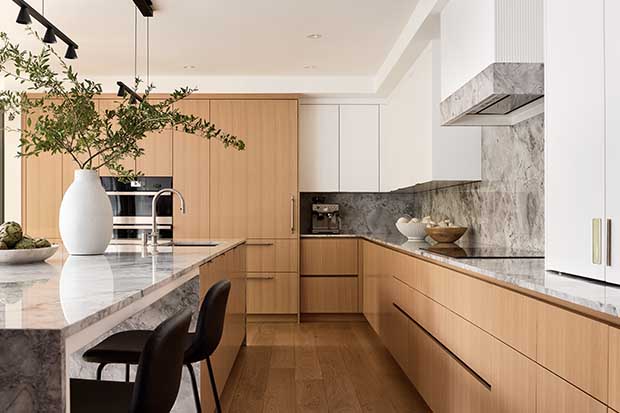 Light-oak lowers and cabinets match the floor of this modern, clean-lined kitchen with white accent cabinets and matte black accents. english cottage-style house