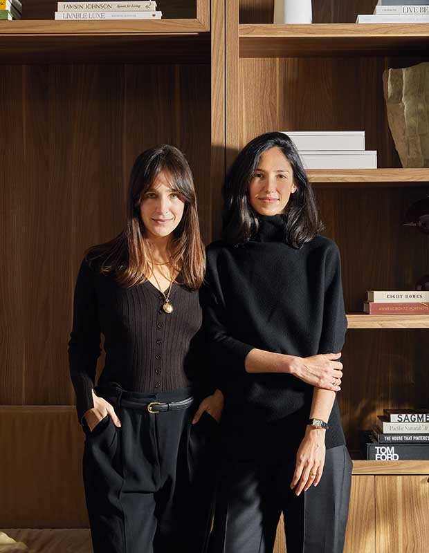 Two women (Maayan and Jo) stand in front of a bookcase. serene city retreat