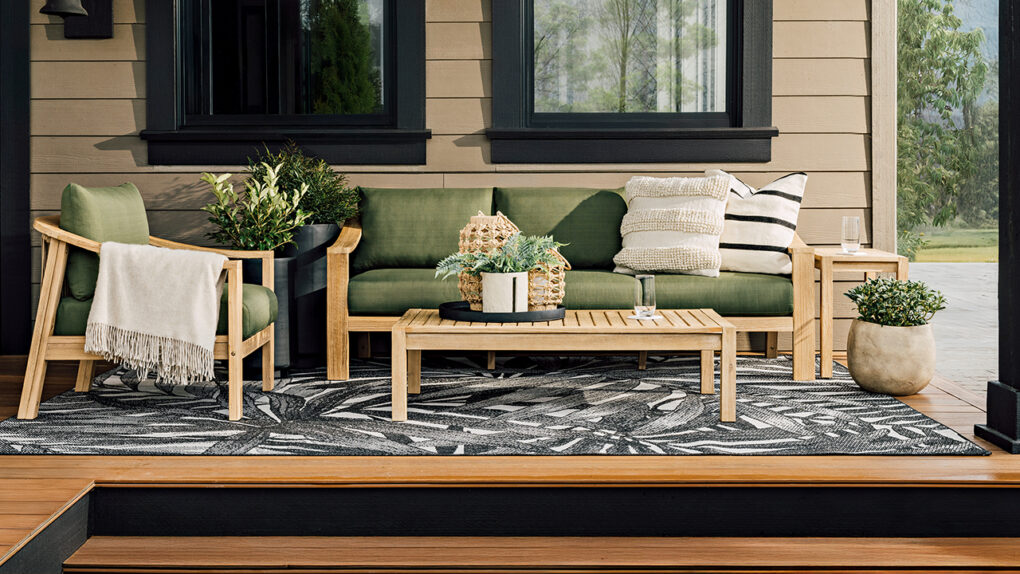 A patio set with green cushions sits outdoors on a patio. sustainable summer accents.