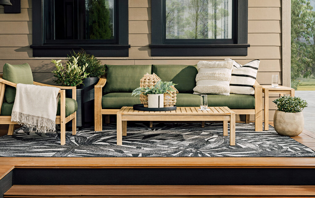 A patio set with green cushions sits outdoors on a patio. sustainable summer accents.