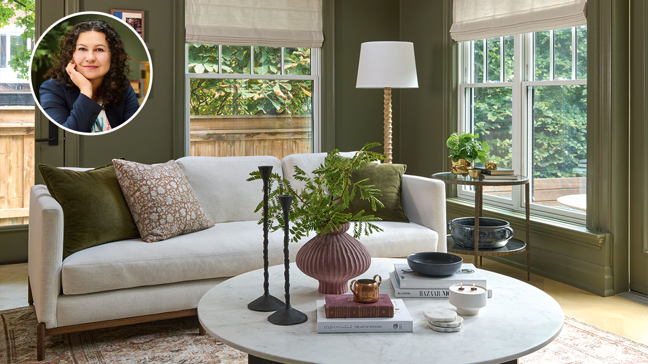 A dark green living room with a vintage rug, exposed wooden beams, and white couch. In the corner is a bubble photo of a caucasian woman with dark curly hair (designer Diane Ernjakovic). home makeover projects