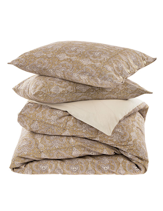 Calm, stylish accents: An image of a folded beige duvet set on a white background.