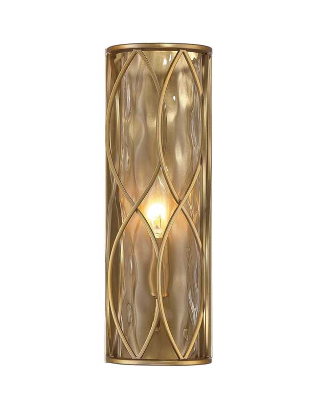 A statement sconce the shape of a cylinder standing on end. Its centre is frosted glass and an interwoven brass line motif swirls around it.