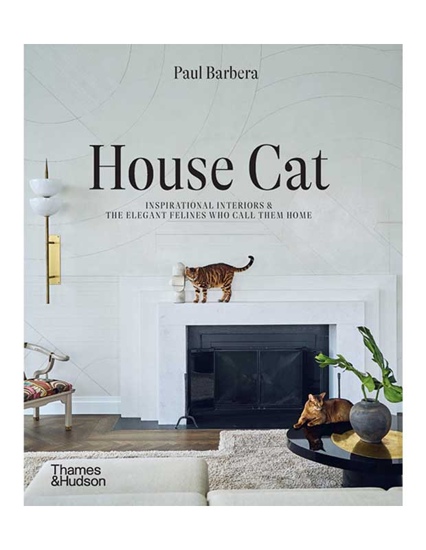 The cover of design book "House Cat." The title is superimposed on an image of a cat standing on a fireplace mantel in a white room.