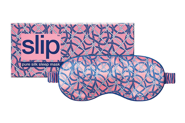 Photograph of a sustainable gift: A pink sleep mask with a knot motif covering it pictured in front of its carrying case.