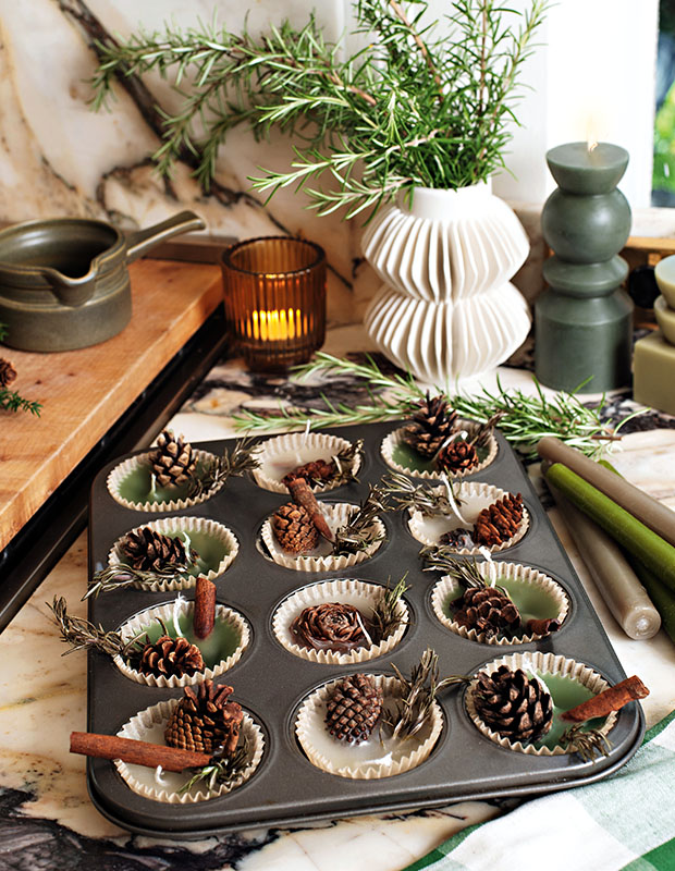 A photograph of a holiday craft: bits of pine cone and needles sit in cups of wax in a muffin tray.