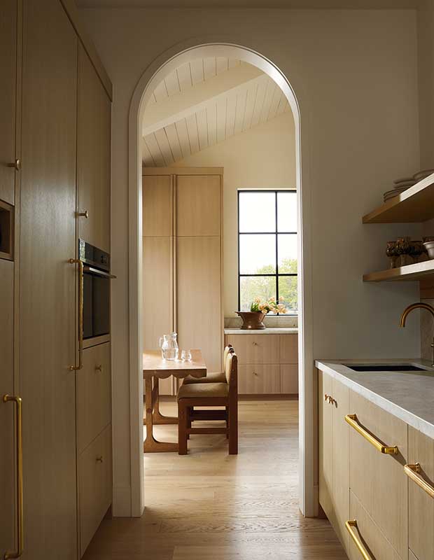 Photo of house featuring English design: A view through an arched doorway. A table and chairs are visible.